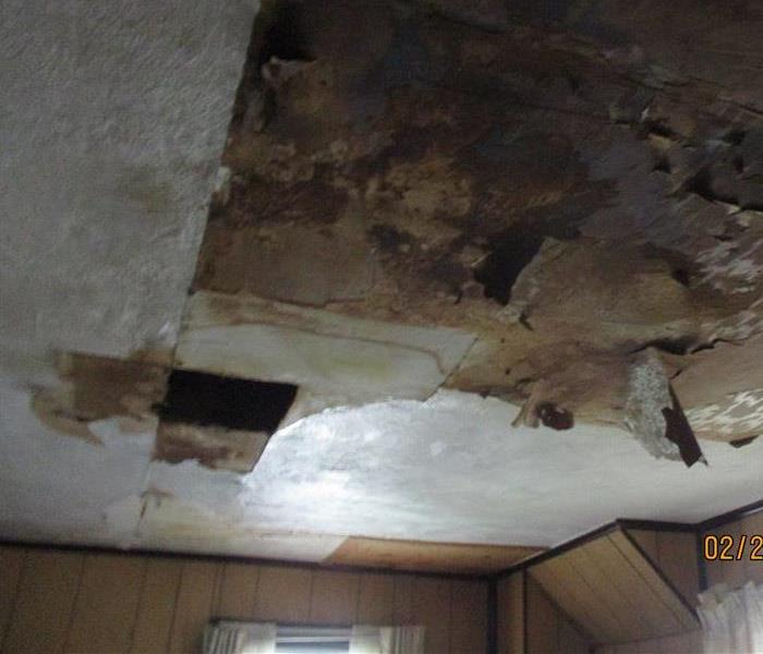 A hole in the ceiling caused by powerful winds from a storm. 