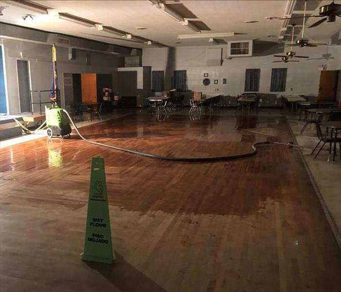 A picture of an empty commercial building with water damage and flooding with SERVPRO equipment cleaning.